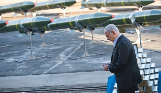 Ministerpräsident Benjamin Netanjahu, hält eine Kugel in den Händen, während er neben beschlagnahmten Raketen an Deck der Klos C steht.